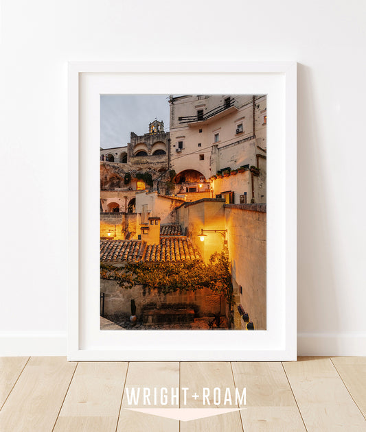 Fine art Photograph of historic Italian buildings at twilight, illuminated by warm amber streetlights, highlighting textured stone facades.