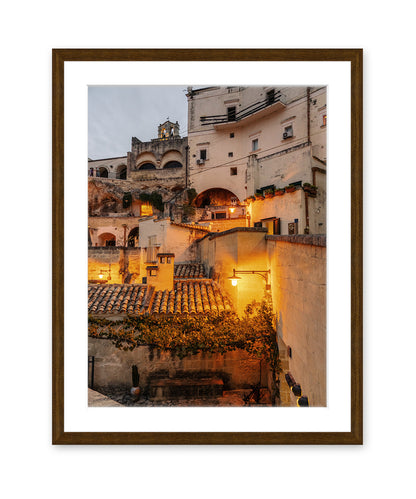 Italy Wall Art featuring Italian architecture at twilight with warm streetlight glow and intricate building details in a dark wood frame.