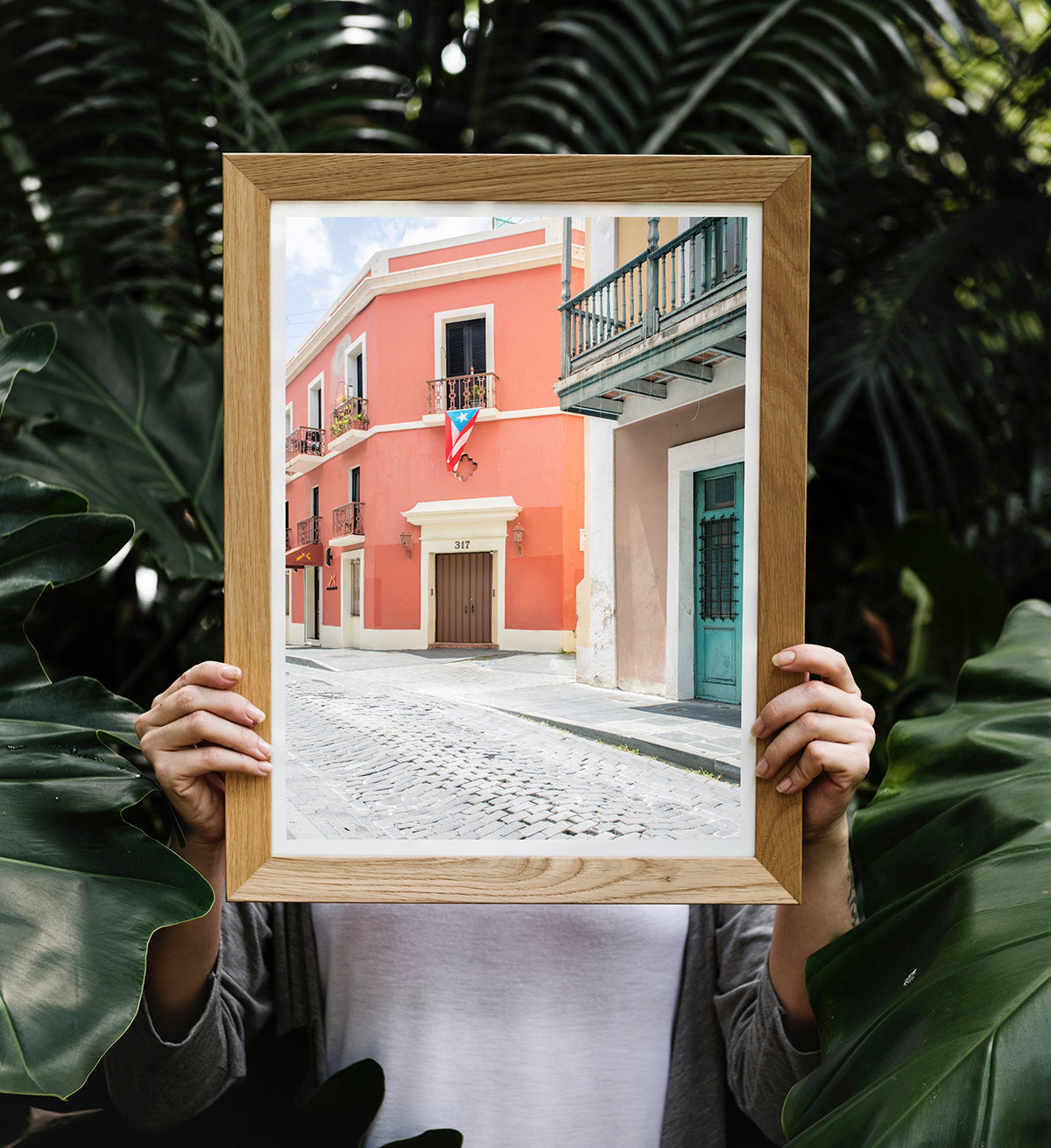 tropical photo holding a framed photograph of a colorful red building in Old San Juan Puerto Rico