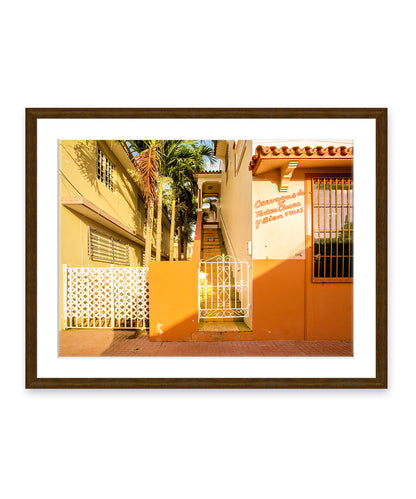 Colorful architecture photography featuring orange buildings in Rincon, Puerto Rico, dark wood frame