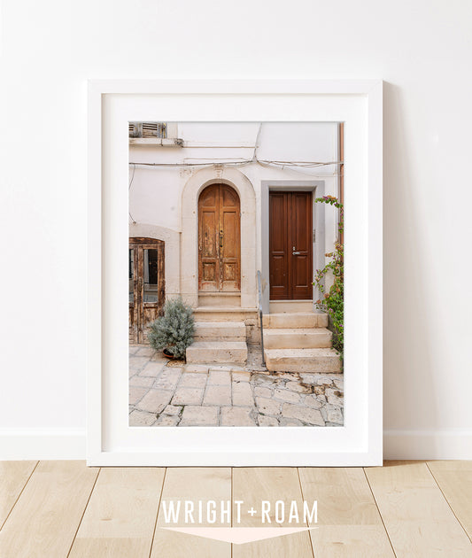 Framed photograph featuring historic doors and cobblestone street in southern italy 