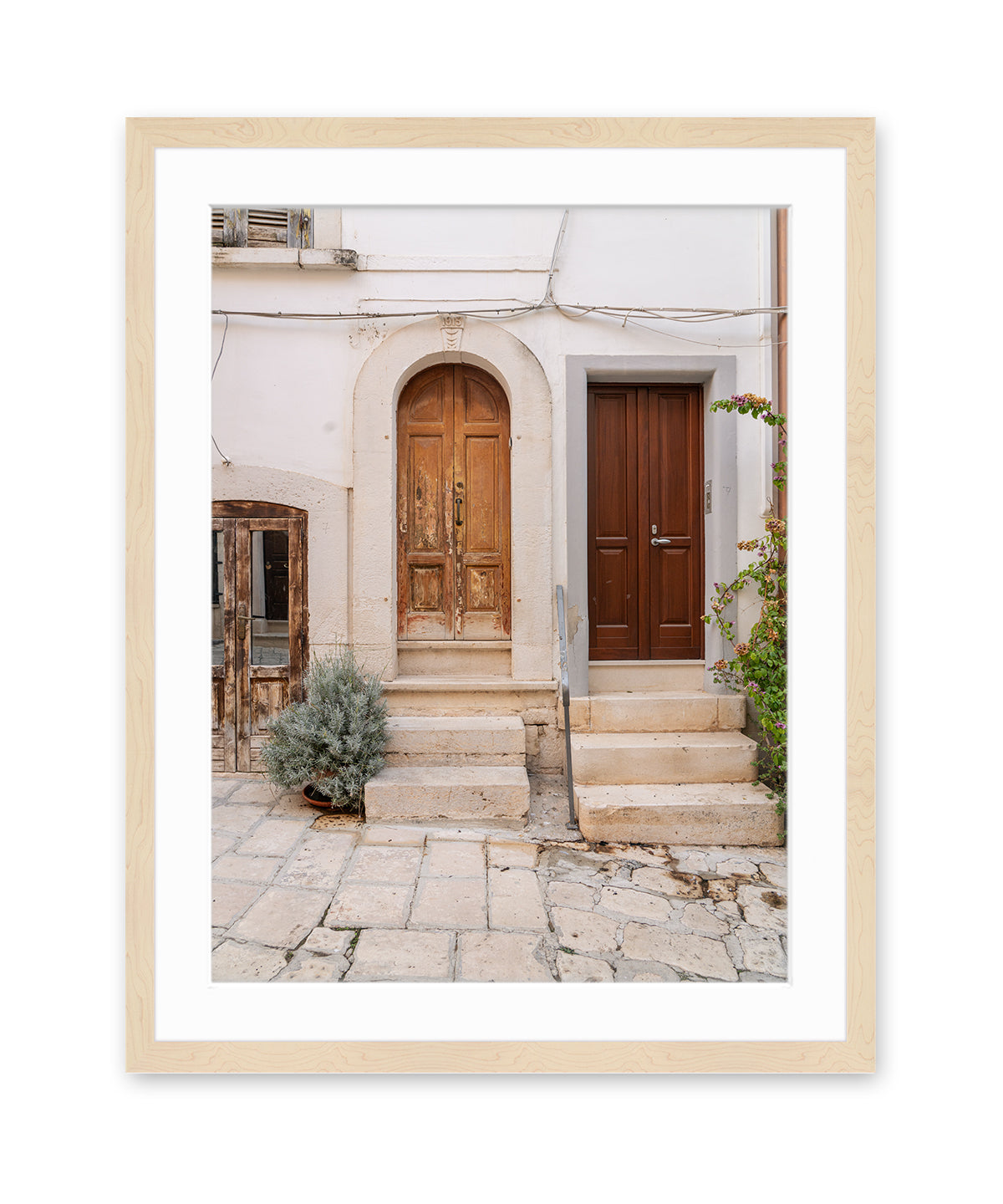 italy photograph in wood frame featuring weathered doors and cobblestone street in Conversano, Puglia. 