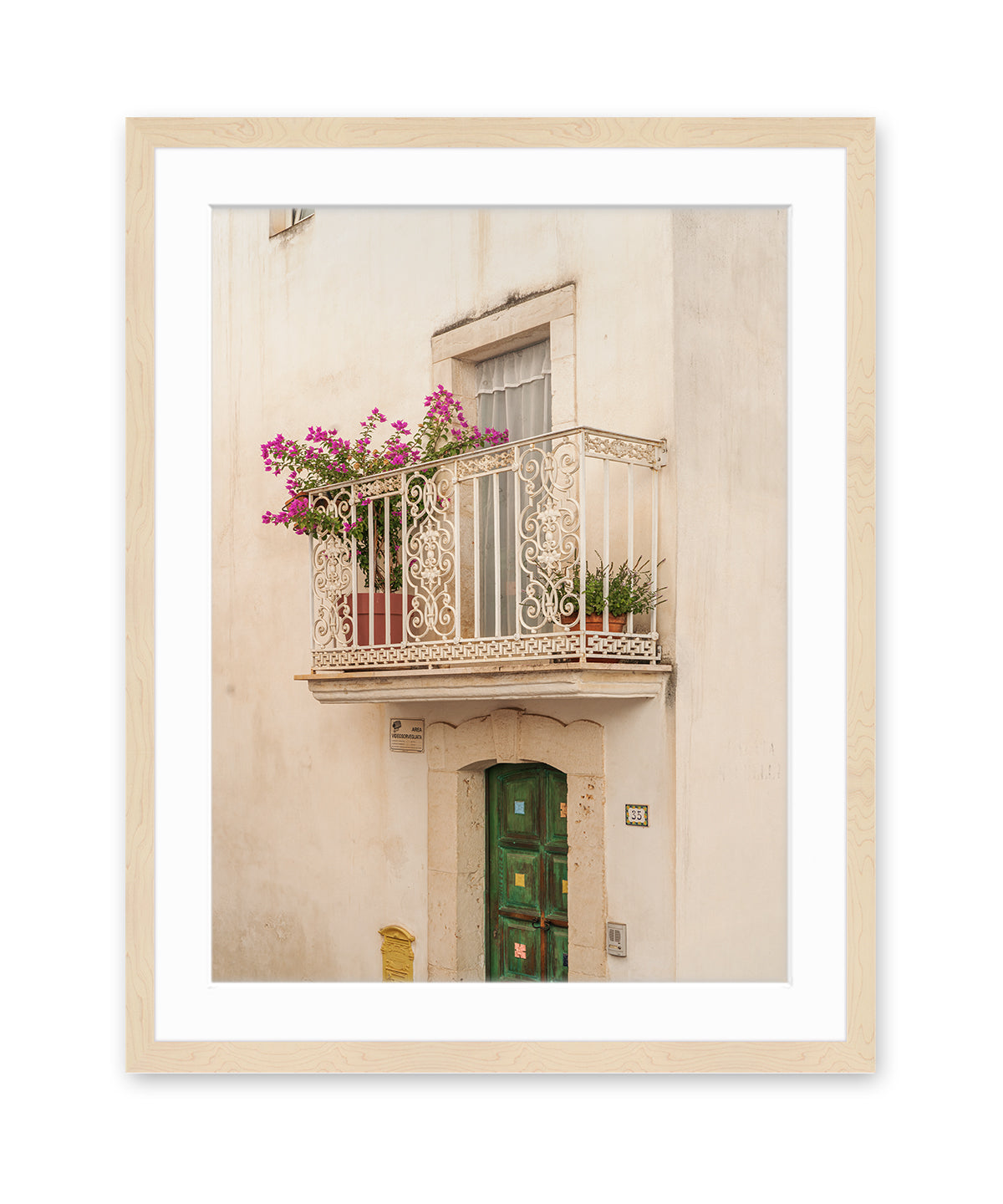 A minimalist fine art photograph in wood frame featuring a textured beige wall, window, and iron balcony in Puglia, Italy.