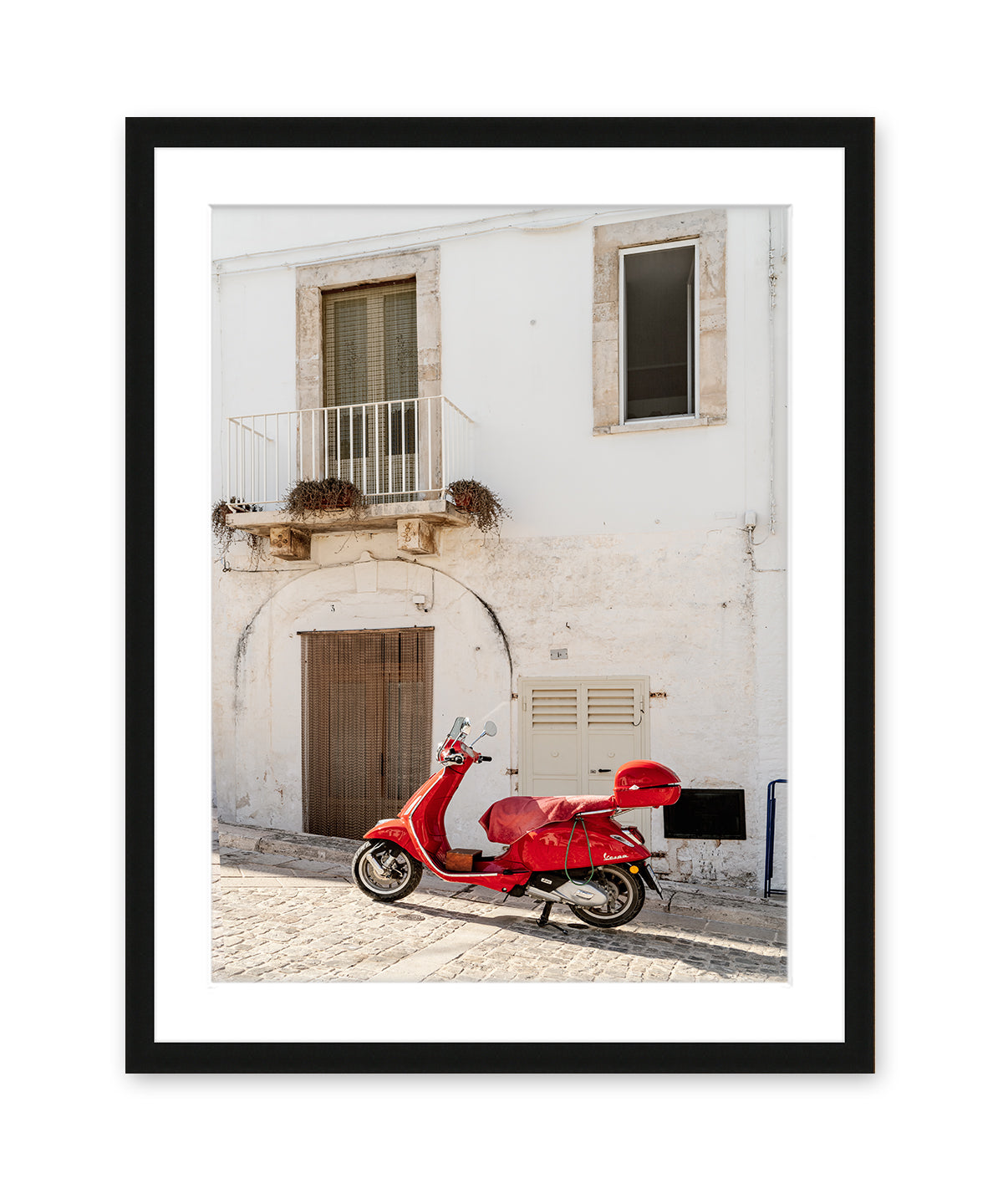 italy wall art in dark black frame featuring white textured building accented by red moped.