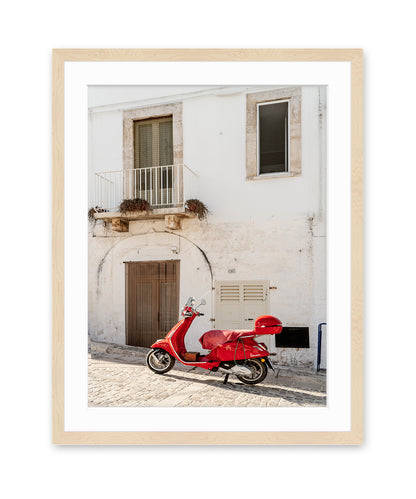 fine art italy photograph in wood frame featuring white textured building accented by red moped.