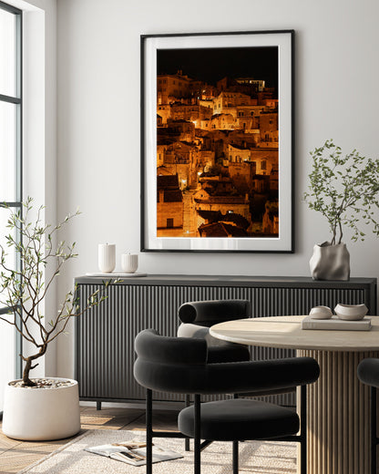 European meets modern decor featuring black accents and framed fine art photograph of Historic city of Matera, Italy at night with glowing amber lights.