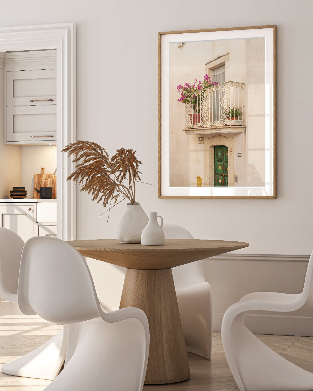 neutral home decor feautring round wood dining room table and framed italy wall art of weathered wall and balcony.