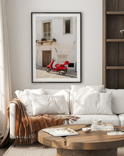 old world living room decor featuring framed weathered building in italy accented by red moped.
