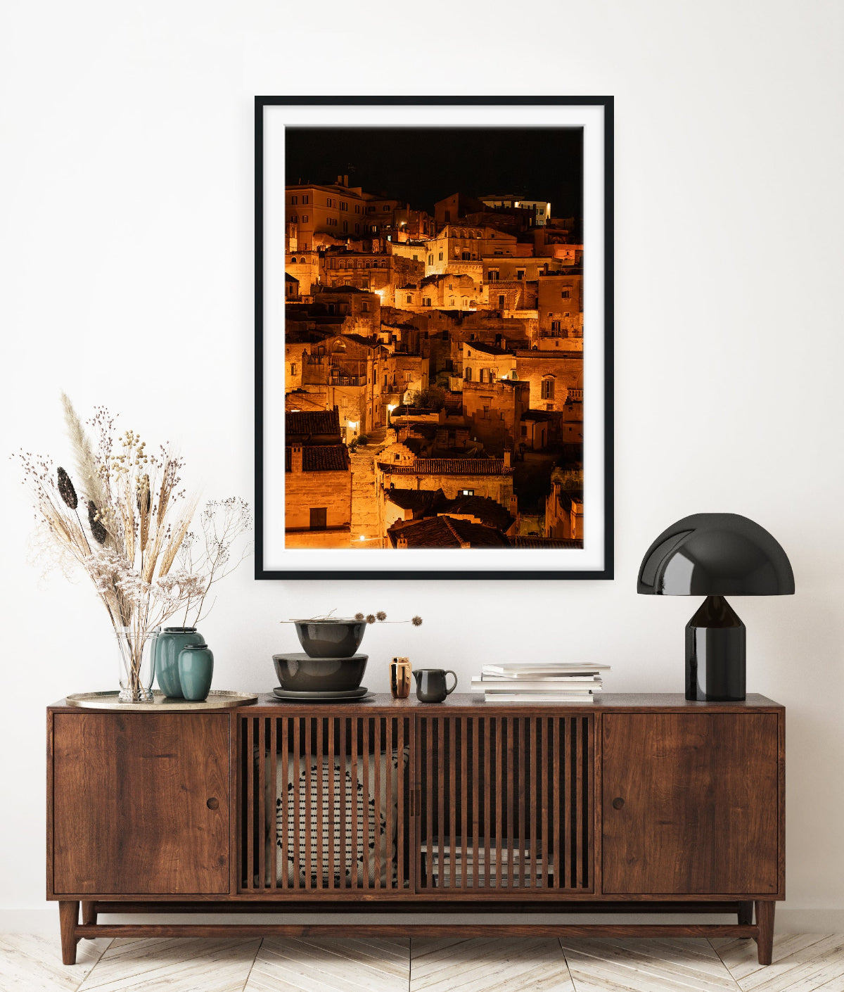European inspired entrway featuring dark wood table and  framed fine art photograph of Historic city of Matera, Italy at night with glowing amber lights.