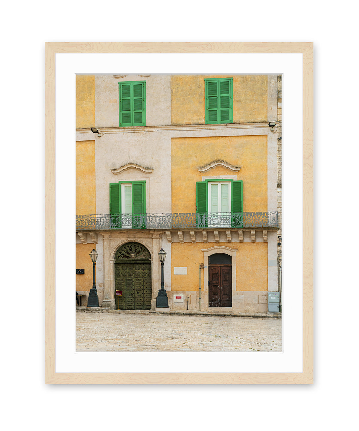 Fine art photograph in wood frame featuring a historic building facade in Matera, Italy filled with soft beige, yellow, and green tones and architectural symmetry