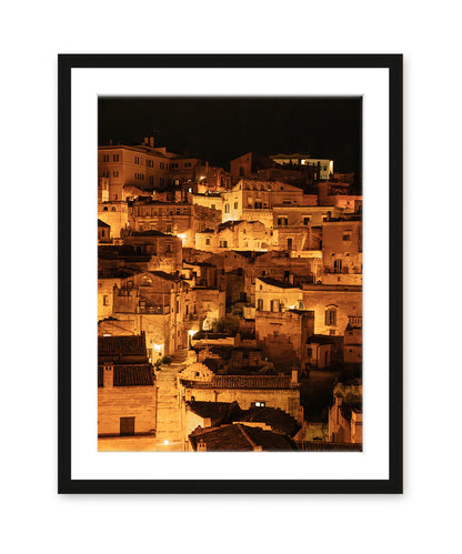 black wood frame fine art photograph of Historic city of Matera, Italy at night with glowing amber lights